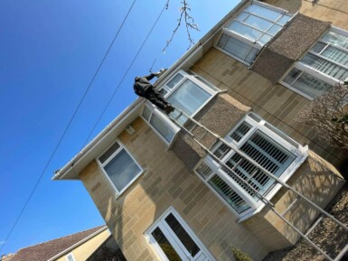 Gutter maintenance and repair in Bath – worker climbing ladder to clear blocked guttering and restore water flow